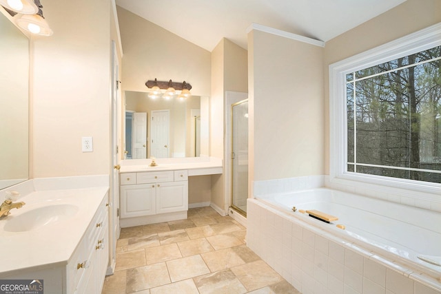 full bathroom featuring a stall shower, a garden tub, a sink, and lofted ceiling