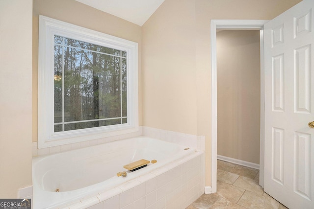 bathroom featuring baseboards and a bath