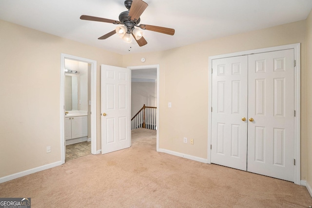 unfurnished bedroom with light carpet, a closet, ensuite bathroom, and baseboards