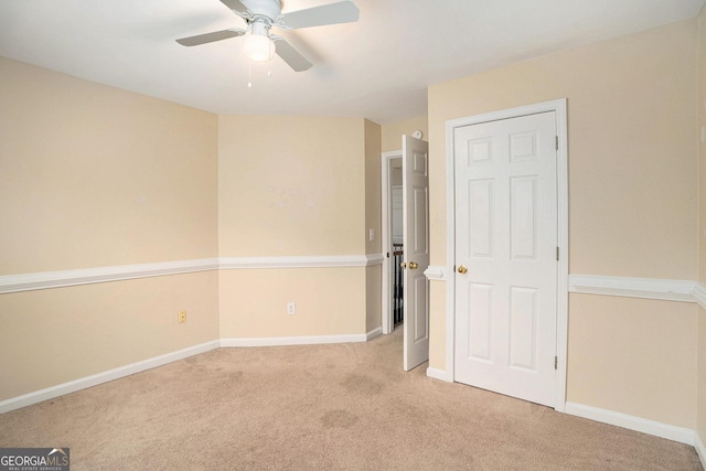 unfurnished bedroom featuring a ceiling fan, light carpet, and baseboards