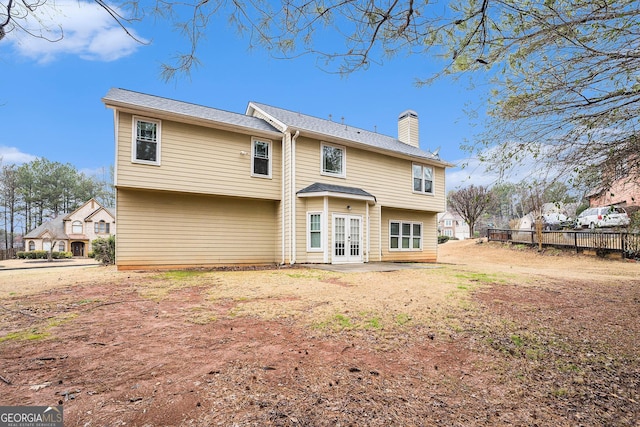 rear view of house featuring french doors, a chimney, a patio area, and fence