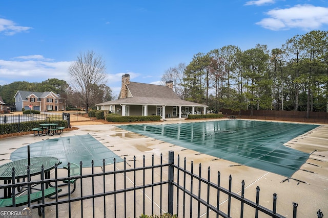 community pool featuring a patio and fence