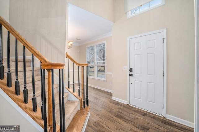 entrance foyer with stairs, crown molding, baseboards, and wood finished floors