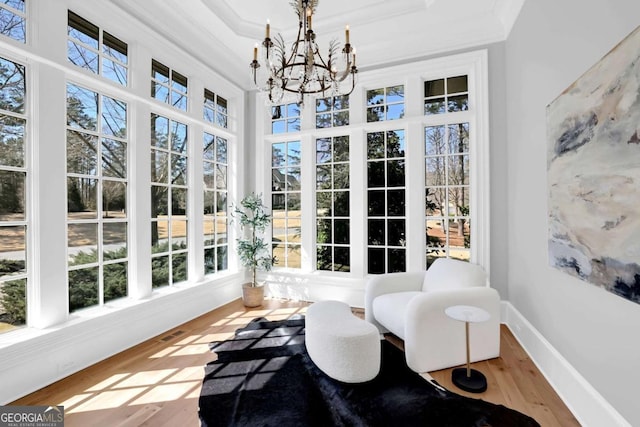 sunroom with a notable chandelier, a tray ceiling, and visible vents