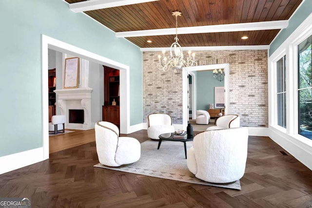 sitting room featuring baseboards, brick wall, beam ceiling, a fireplace, and a notable chandelier