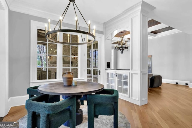 dining area with a chandelier, crown molding, light wood-type flooring, and baseboards