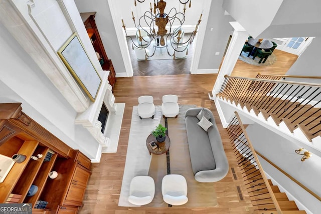 interior space with a chandelier, stairs, baseboards, and wood finished floors