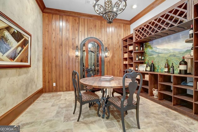 wine area featuring stone finish flooring, wood walls, and crown molding