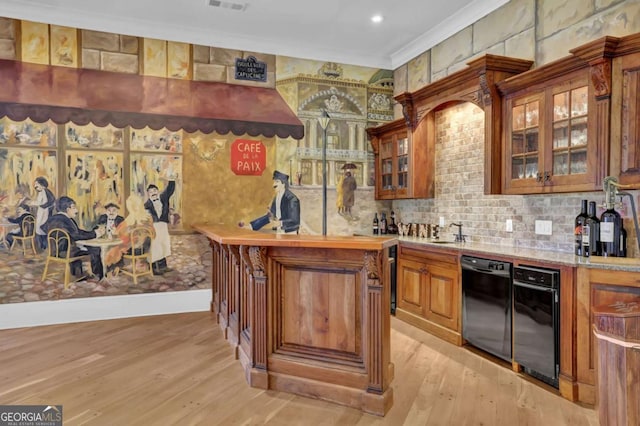 bar with light wood-style flooring, ornamental molding, a sink, wet bar, and dishwasher