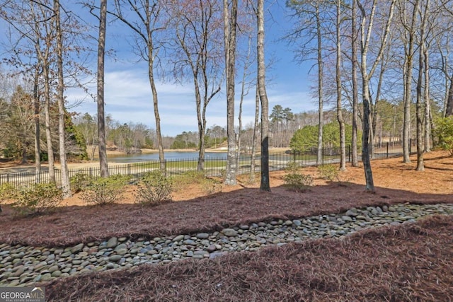 view of yard with a water view and fence