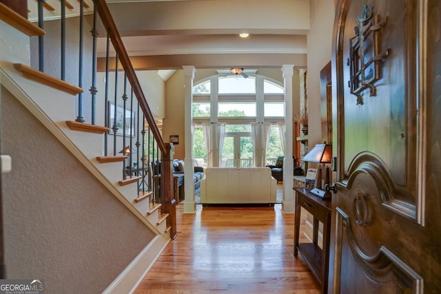 entryway with decorative columns and wood finished floors