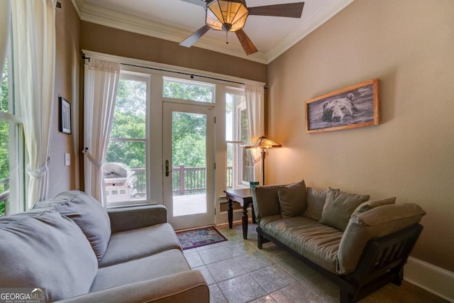 living room featuring ornamental molding, baseboards, and a ceiling fan