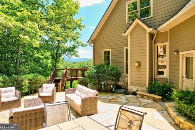 view of patio / terrace with outdoor lounge area, a wooden deck, and stairs