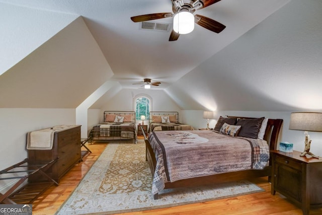 bedroom featuring vaulted ceiling, ceiling fan, light wood-type flooring, and visible vents