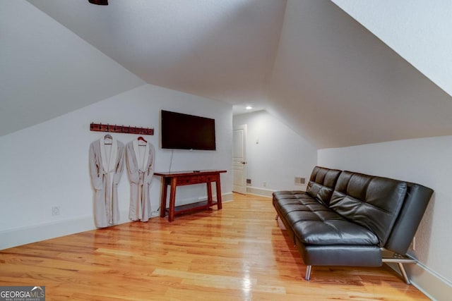 living area featuring lofted ceiling, light wood-style flooring, recessed lighting, visible vents, and baseboards