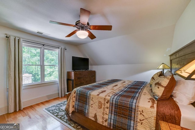 bedroom with lofted ceiling, visible vents, ceiling fan, wood finished floors, and baseboards