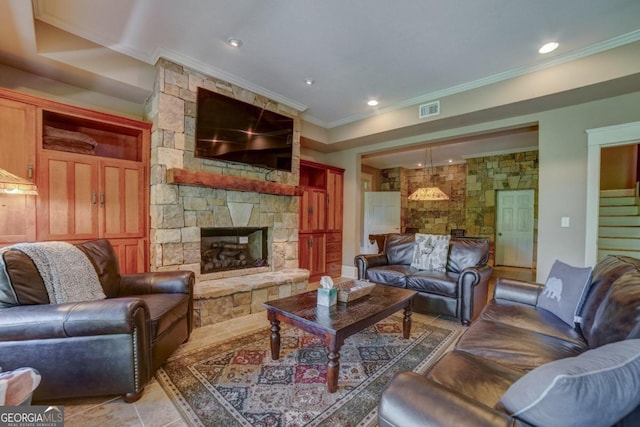 living area featuring recessed lighting, visible vents, ornamental molding, a stone fireplace, and stairs