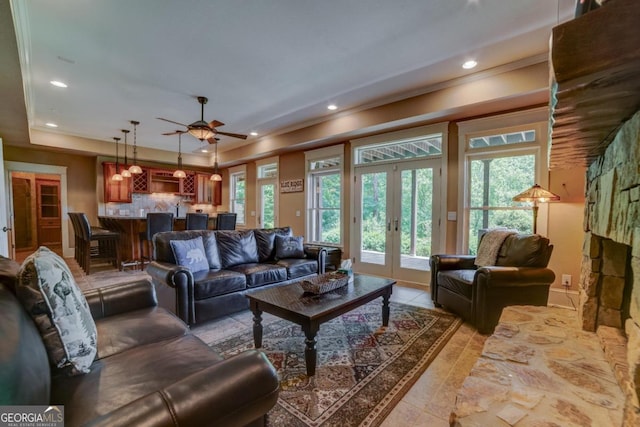 living room featuring french doors, recessed lighting, a raised ceiling, and a healthy amount of sunlight