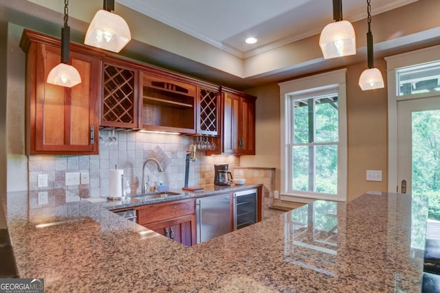 kitchen featuring brown cabinetry, a sink, dishwashing machine, and light stone countertops