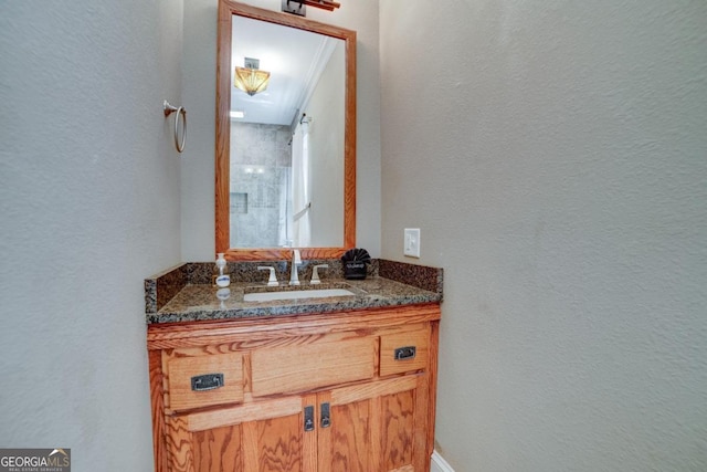 bathroom featuring a textured wall and vanity