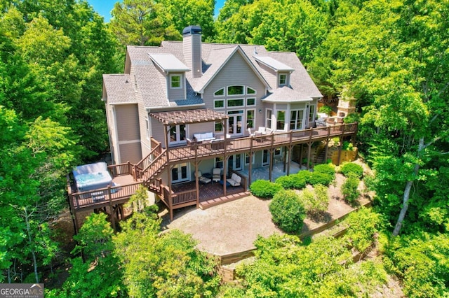 back of house with a chimney, a patio area, a deck, and a pergola