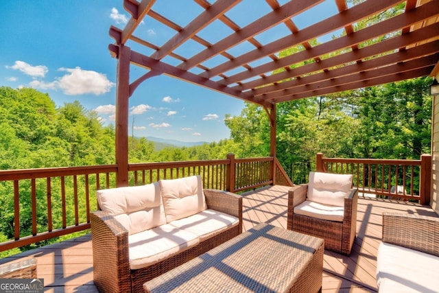 wooden terrace featuring a forest view, outdoor lounge area, and a pergola