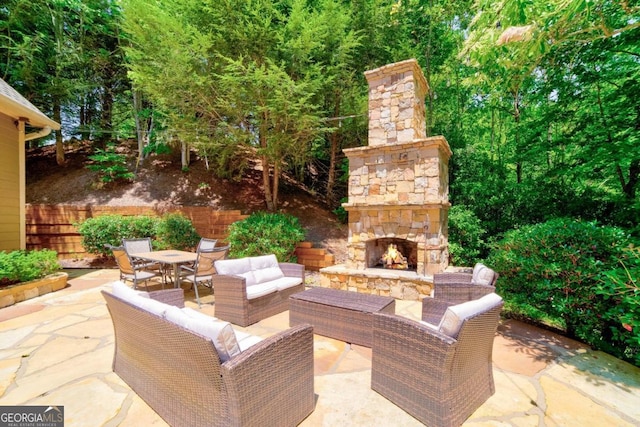 view of patio with outdoor dining space, fence, and an outdoor living space with a fireplace