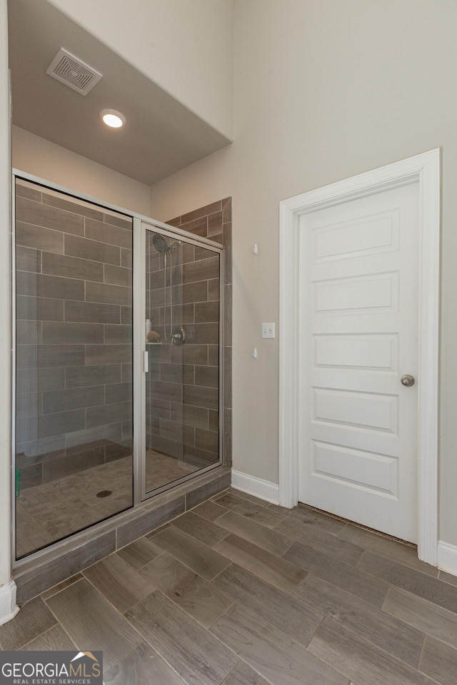 full bathroom with a shower stall, visible vents, and baseboards