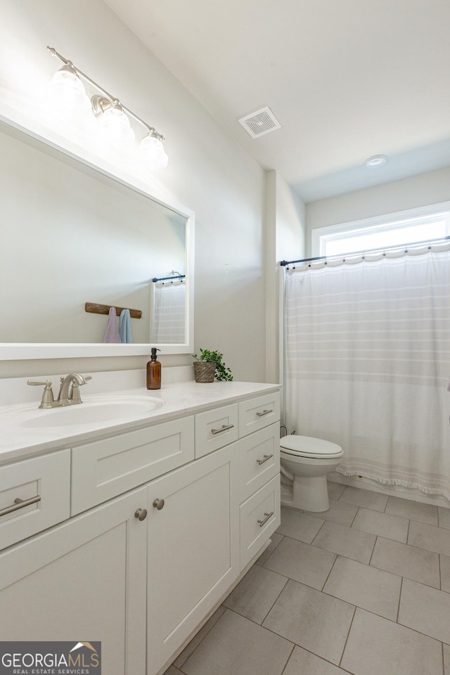 bathroom featuring toilet, tile patterned flooring, vanity, and visible vents