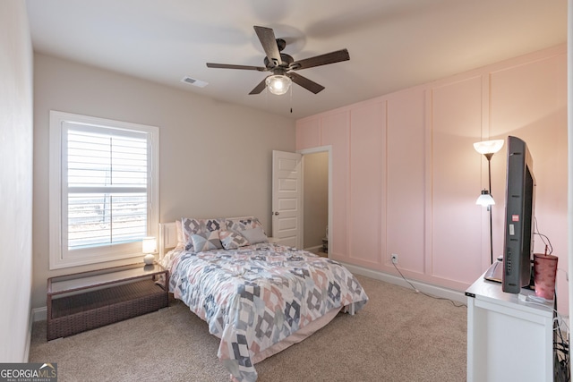 bedroom with light carpet, visible vents, and a ceiling fan