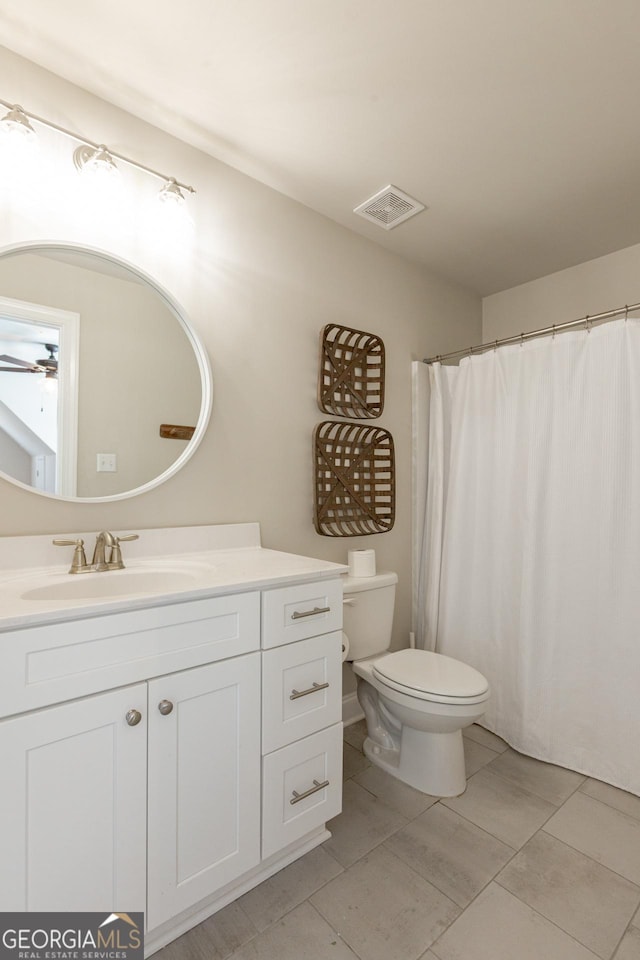 bathroom with visible vents, toilet, ceiling fan, vanity, and tile patterned floors