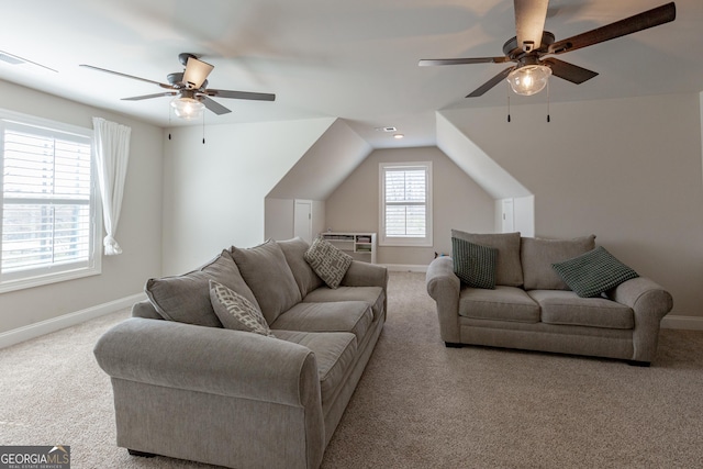 living area featuring ceiling fan, lofted ceiling, visible vents, baseboards, and carpet