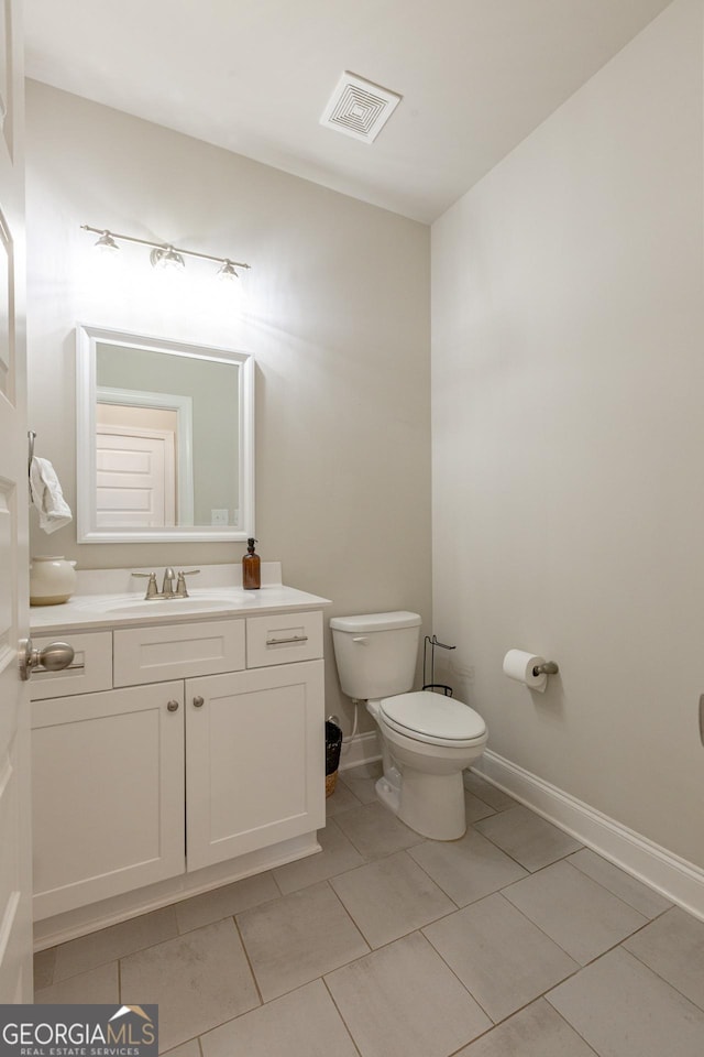 bathroom featuring toilet, baseboards, visible vents, and vanity