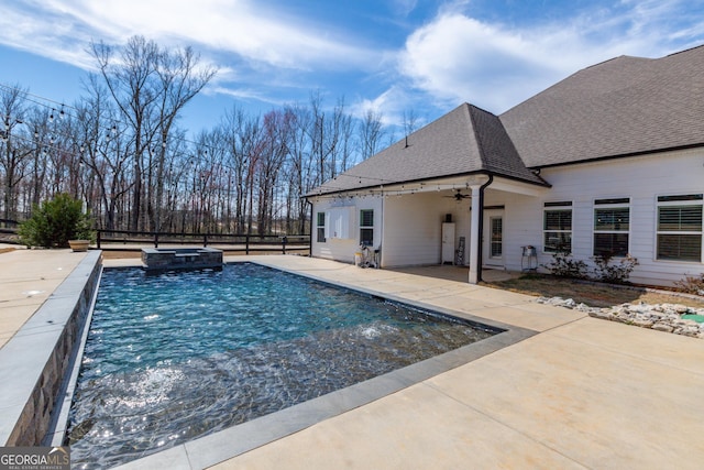 view of swimming pool featuring a pool with connected hot tub, a patio area, ceiling fan, and fence