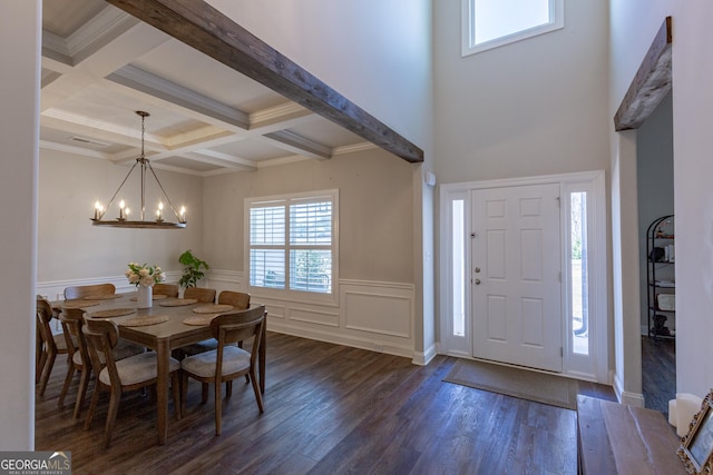 foyer entrance featuring beam ceiling, a notable chandelier, dark wood finished floors, wainscoting, and coffered ceiling