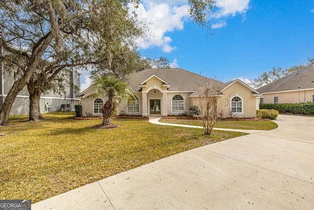 view of front of house with a shingled roof and a front yard