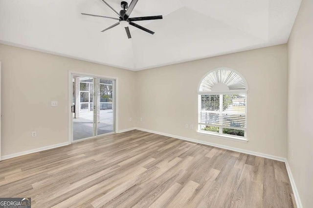 spare room with light wood-type flooring, baseboards, and a wealth of natural light