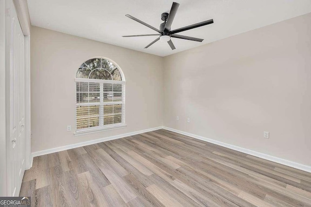 spare room with ceiling fan, wood finished floors, and baseboards