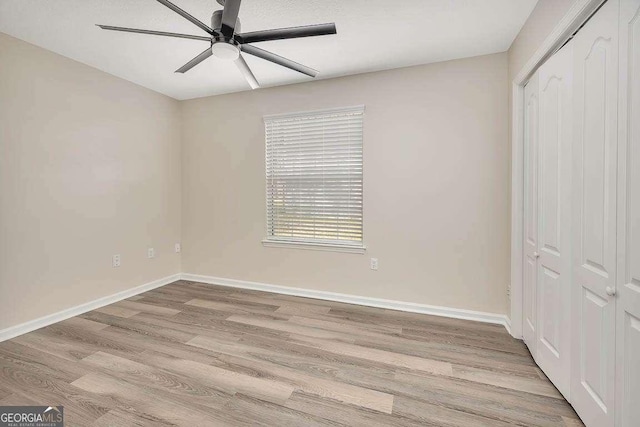 unfurnished bedroom featuring light wood finished floors, ceiling fan, baseboards, and a closet