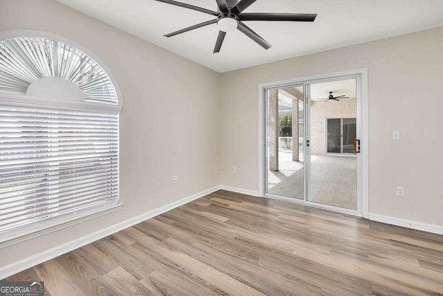 unfurnished room featuring wood finished floors, a ceiling fan, and baseboards