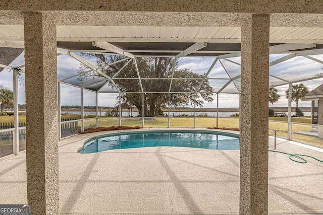 outdoor pool with glass enclosure and a patio area