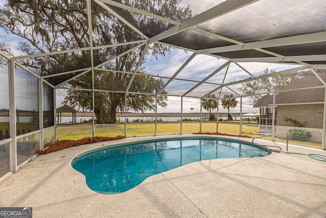 outdoor pool with glass enclosure, a patio, and a lawn