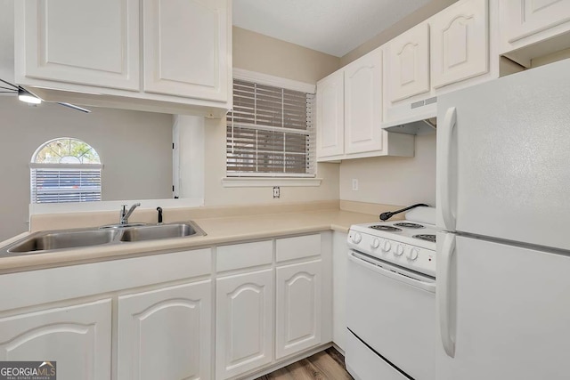 kitchen featuring light countertops, white cabinets, a sink, white appliances, and under cabinet range hood