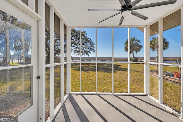 unfurnished sunroom featuring a water view and ceiling fan