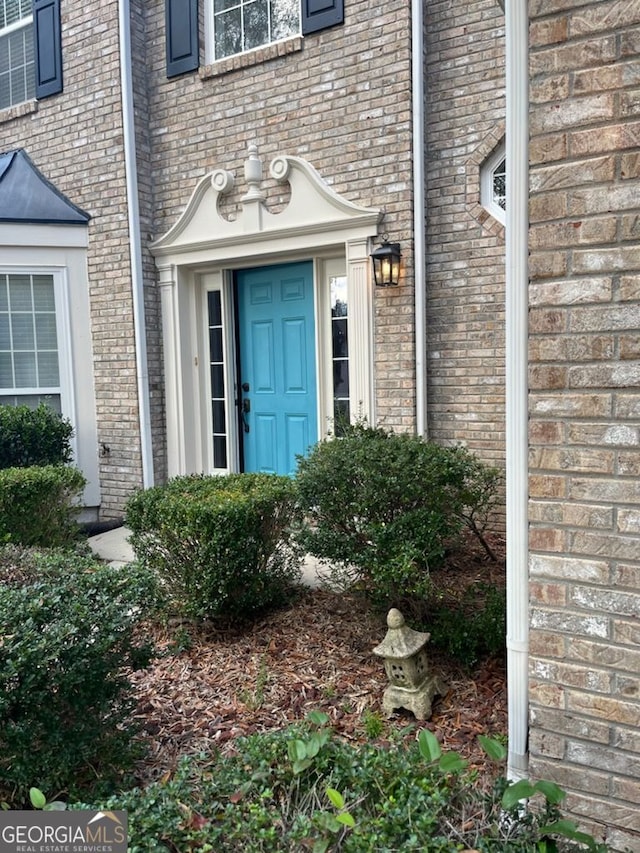 doorway to property featuring brick siding