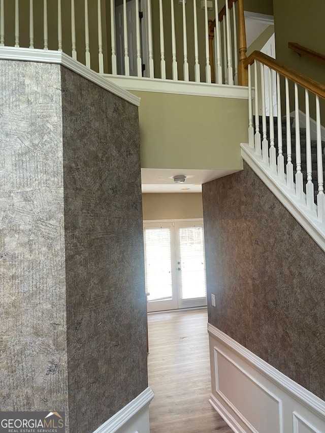 stairs featuring a wainscoted wall, a decorative wall, and wood finished floors