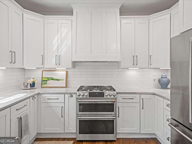 kitchen featuring light stone counters, appliances with stainless steel finishes, backsplash, and white cabinetry