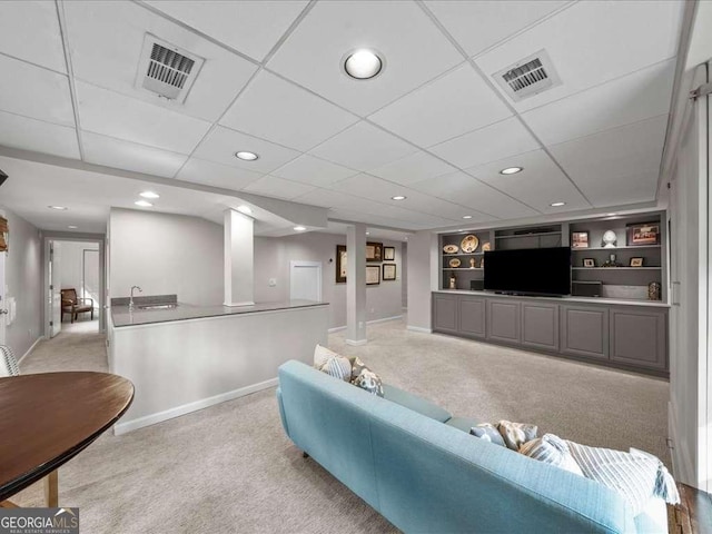 carpeted living area with baseboards, visible vents, and built in features