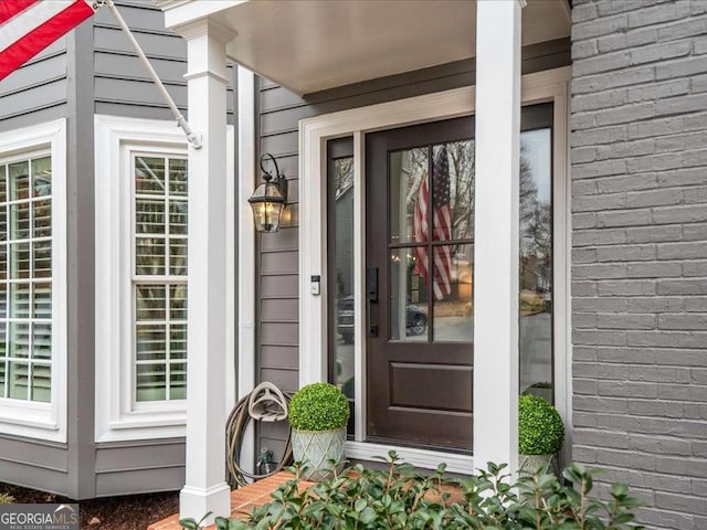 view of exterior entry featuring brick siding