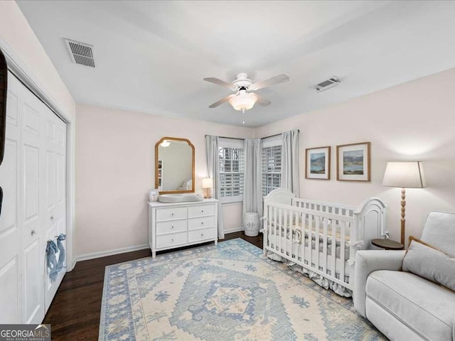 bedroom featuring a closet, visible vents, baseboards, and wood finished floors